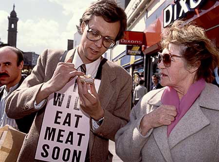 PICTURE: color photo of Gibson showing the meat hors d'oeuvre to a woman.